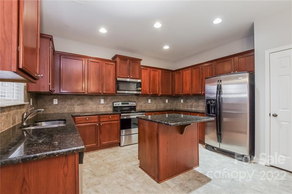 6415 Hermsley Road Charlotte, NC 28278 - Photo 6 of 15 a kitchen with stainless steel appliances granite countertop a stove a sink dishwasher a refrigerator and a microwave
