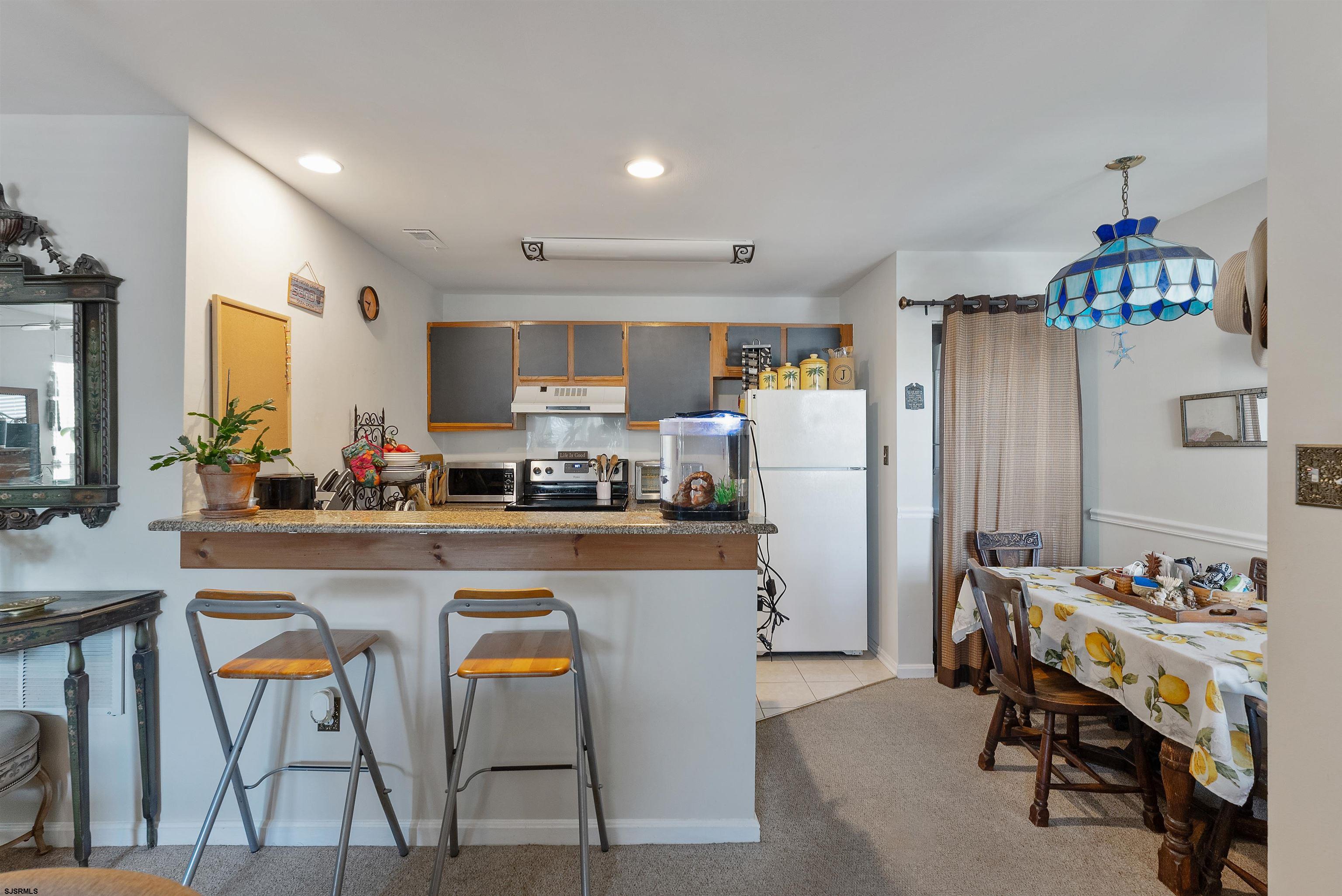 144 Meadow Ridge Road, Unit 144 Galloway Township, NJ 08205 - Photo 12 of 16 a kitchen with refrigerator and chairs