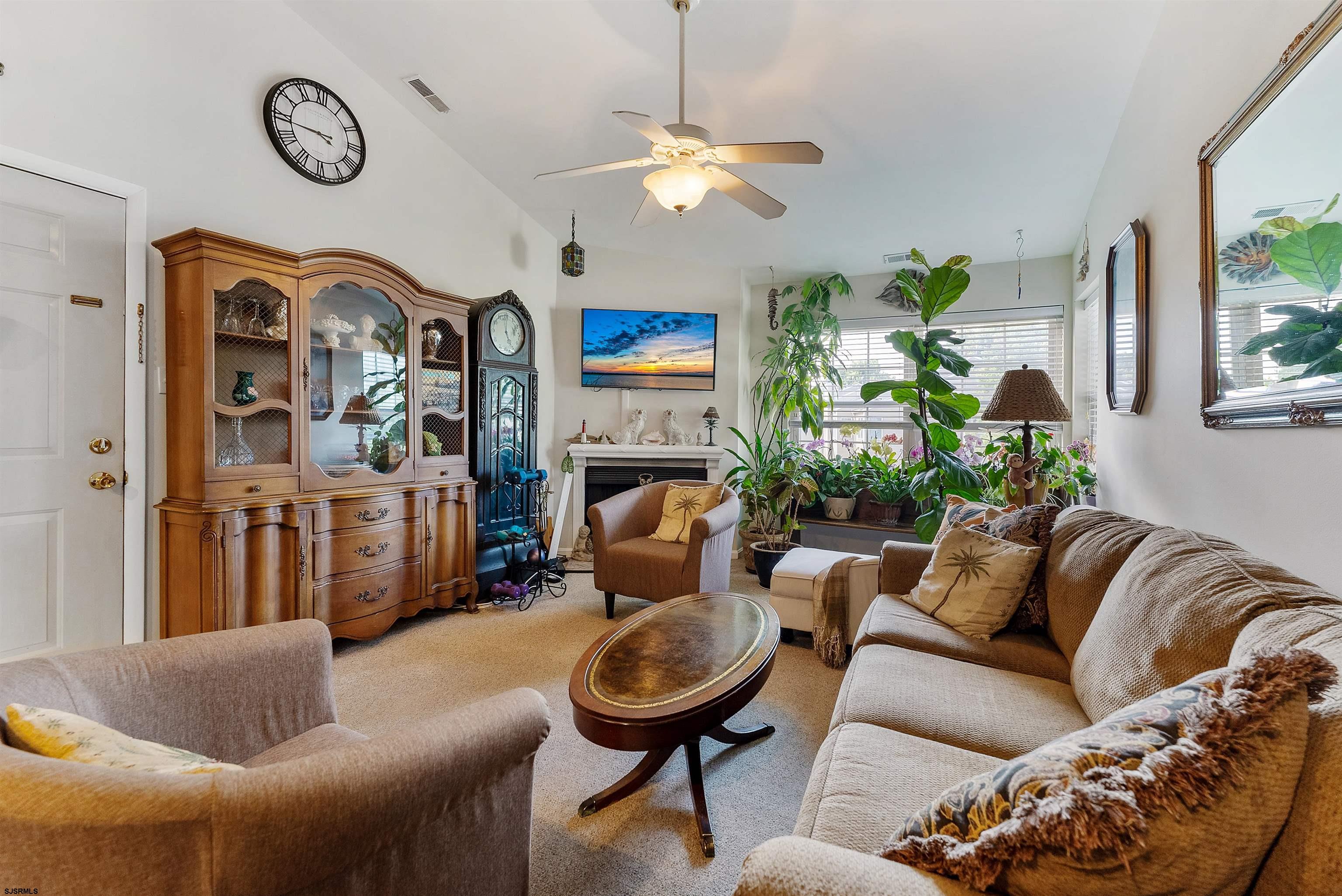 144 Meadow Ridge Road, Unit 144 Galloway Township, NJ 08205 - Photo 5 of 16 a living room with furniture a fireplace and a chandelier
