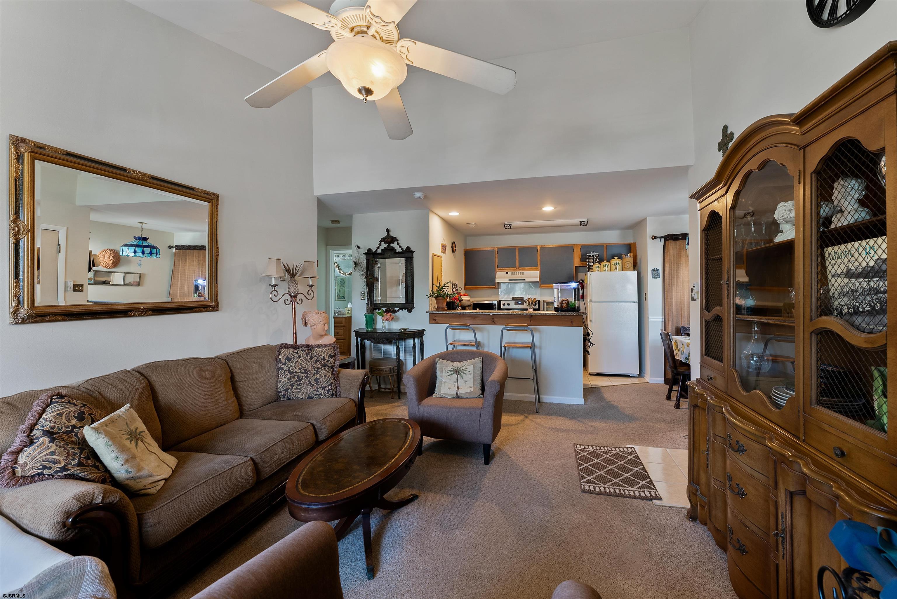 144 Meadow Ridge Road, Unit 144 Galloway Township, NJ 08205 - Photo 7 of 16 a living room with furniture kitchen view and a fireplace