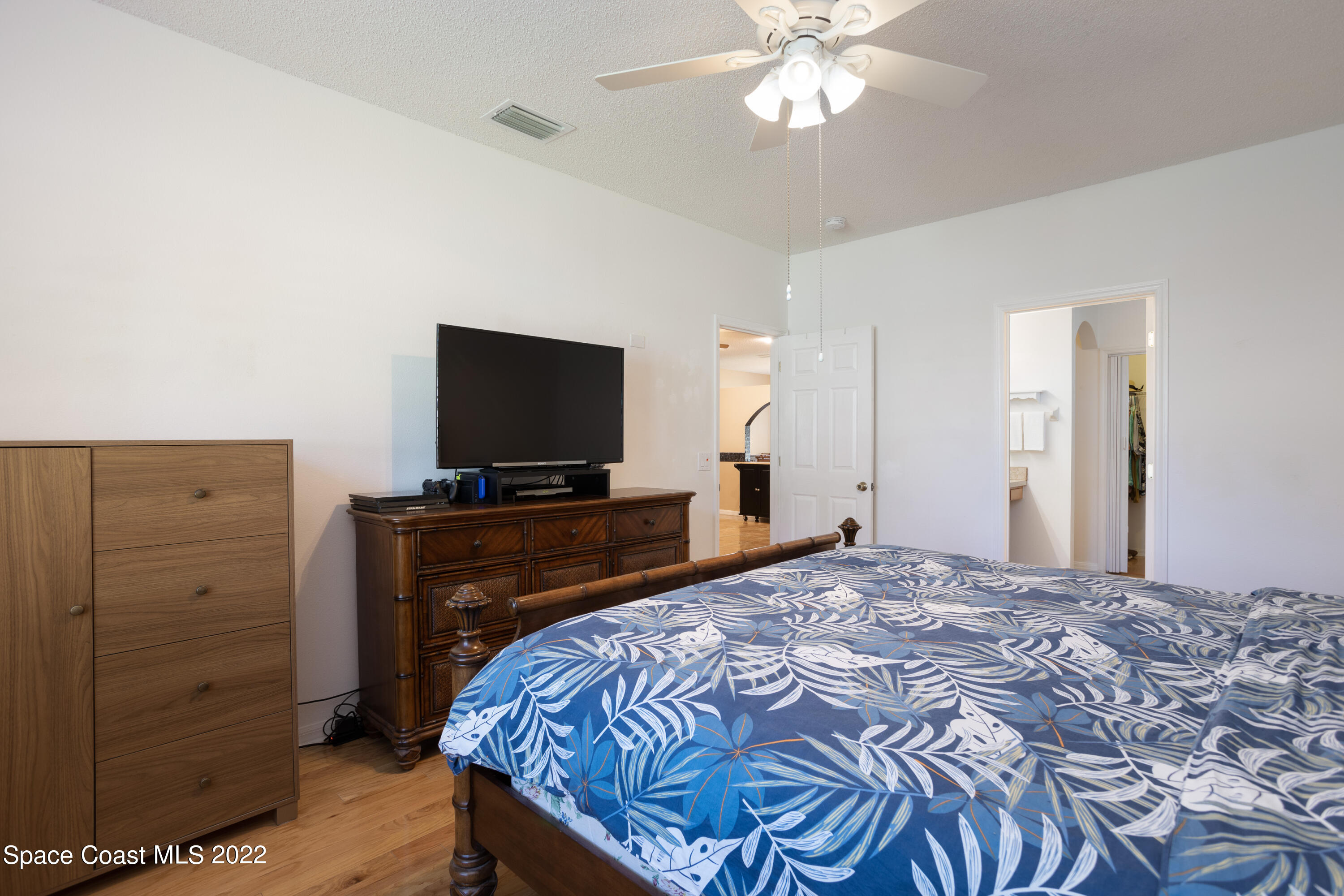 1354 Enclave Drive Rockledge, FL 32955 - Photo 18 of 30 a bedroom with a bed and a flat tv screen on dresser