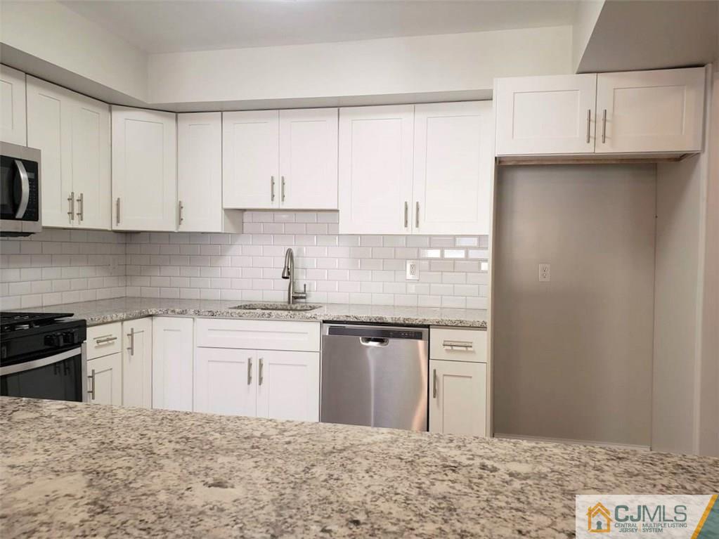 148 Redpine Loop Old Bridge, NJ 08857 - Photo 8 of 20 a kitchen with stainless steel appliances granite countertop a sink stove and refrigerator