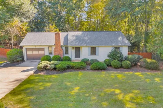 a view of a house with a big yard and large trees