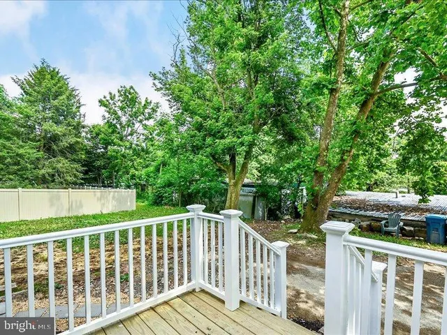 a balcony with wooden floor and yard in the back