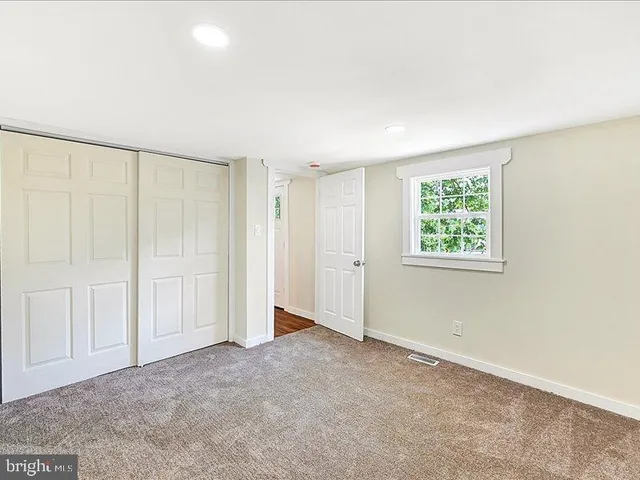 an empty room with windows and closet