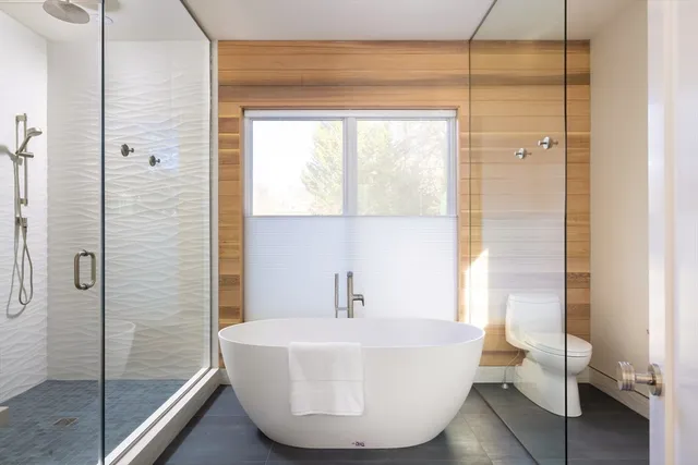 a bathroom with a white tub shower vanity and a sink