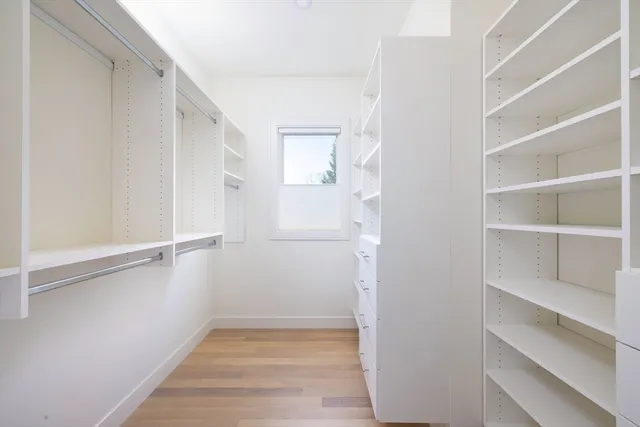 a view of walk in closet with empty racks
