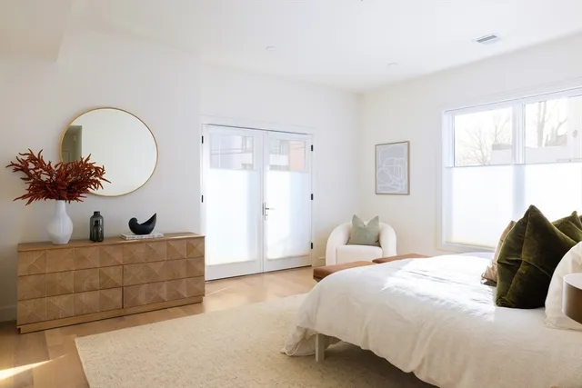 a bedroom with a bed a couch and a large window