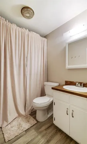 a bathroom with a granite countertop sink a toilet and a mirror