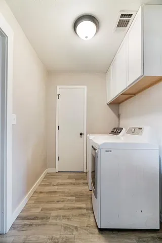 a utility room with cabinets washer and dryer
