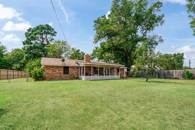 a view of a house with a yard and trees