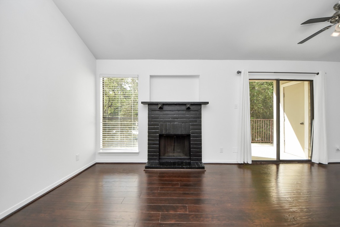 Bright living area featuring a cozy fireplace, large window and sliding doors that fills the space with natural light