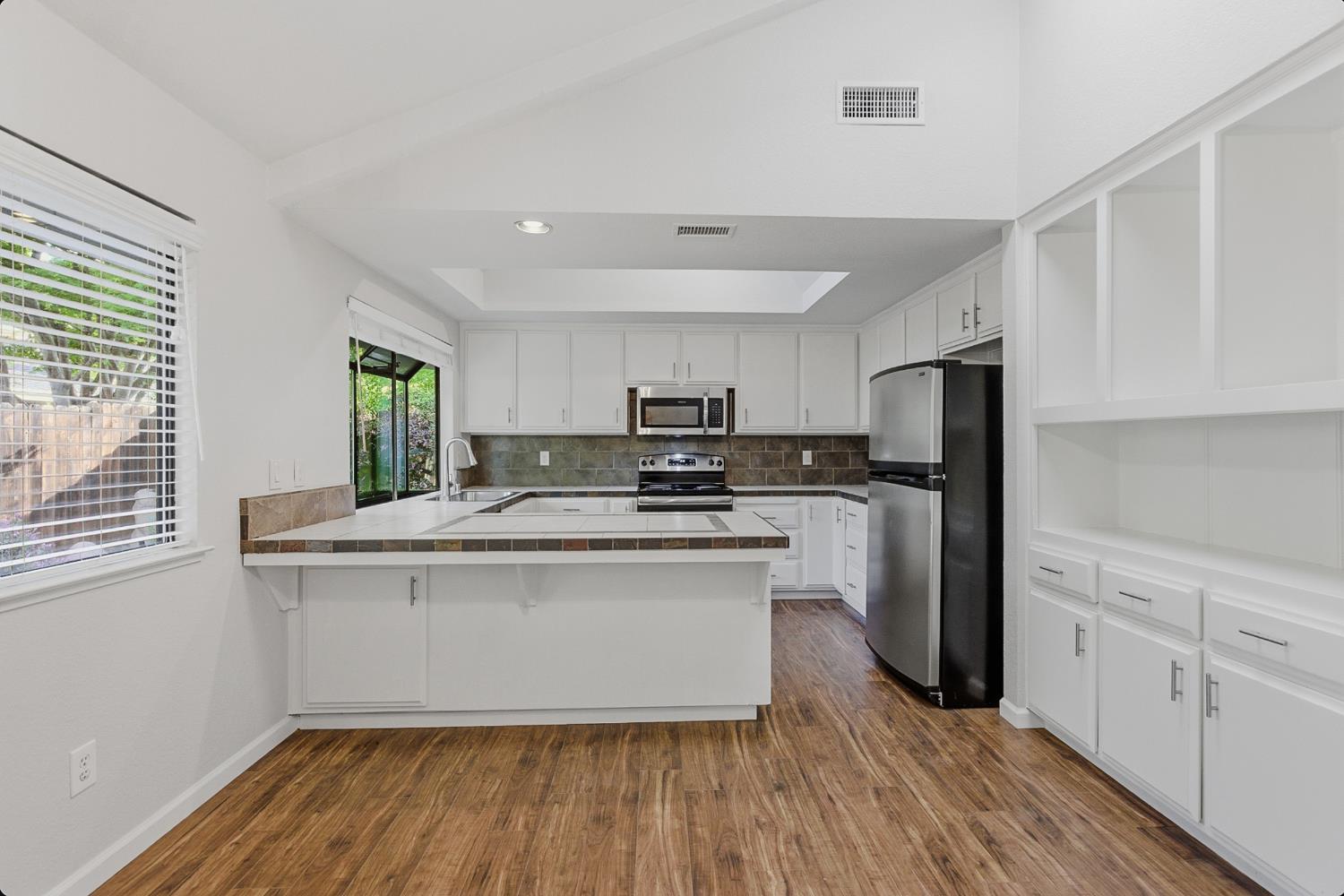 1175 Rose Tree Way Sacramento, CA 95831 - Photo 11 of 33 a kitchen with kitchen island granite countertop a sink cabinets and stainless steel appliances
