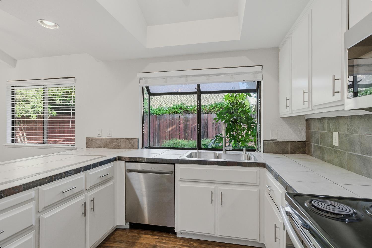 1175 Rose Tree Way Sacramento, CA 95831 - Photo 13 of 33 a kitchen with granite countertop white cabinets and a window