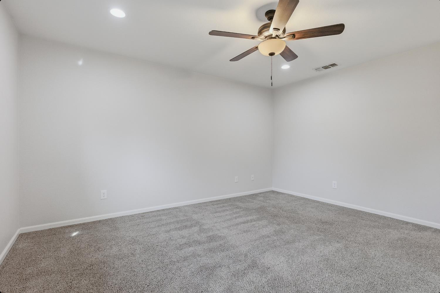 1175 Rose Tree Way Sacramento, CA 95831 - Photo 16 of 33 an empty room with a chandelier fan and windows