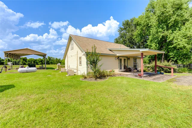 a view of an house with swimming pool lawn chairs and a yard