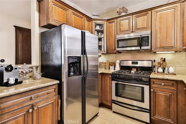 a kitchen with stainless steel appliances granite countertop a refrigerator stove and microwave