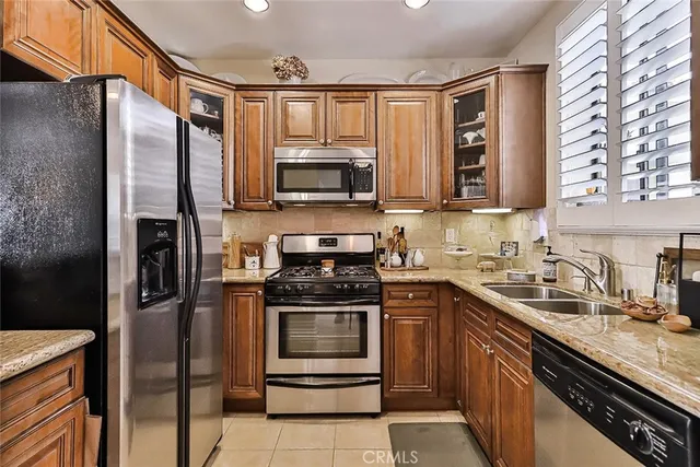 a kitchen with stainless steel appliances granite countertop a refrigerator stove and sink