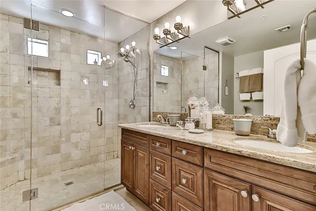 a bathroom with a granite countertop sink a mirror and shower