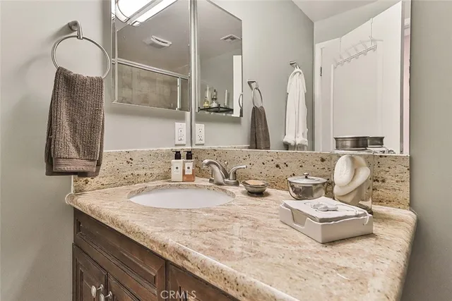 a bathroom with a granite countertop sink and a mirror