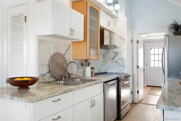a kitchen with stainless steel appliances granite countertop a sink and a refrigerator