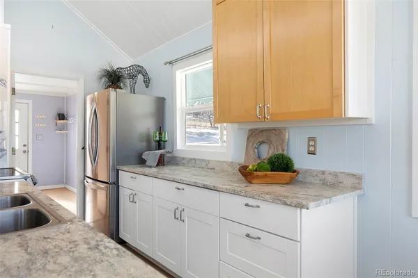 a kitchen with stainless steel appliances granite countertop a sink a refrigerator and a granite counter tops