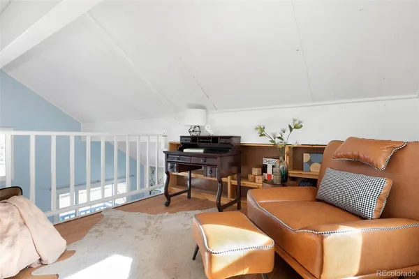 a living room with furniture a piano and a potted plant