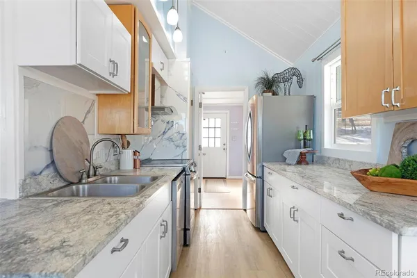 a kitchen with stainless steel appliances granite countertop a sink stove and cabinets