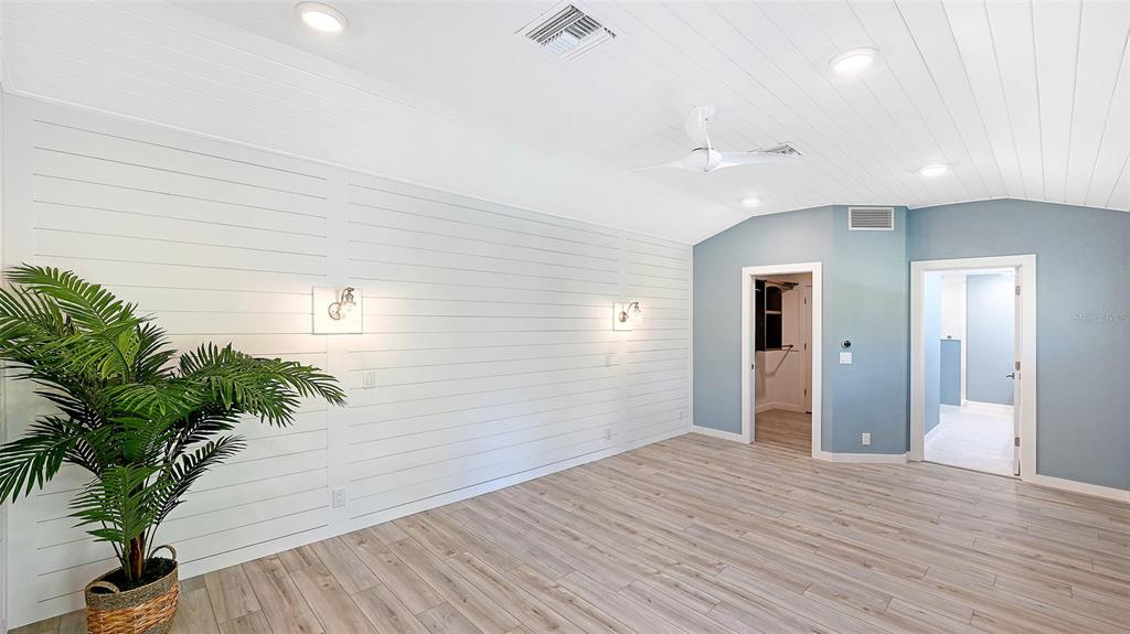 7221 Plovers Way Sarasota, FL 34242 - Photo 24 of 100 a view of a hallway with wooden floor and a potted plant