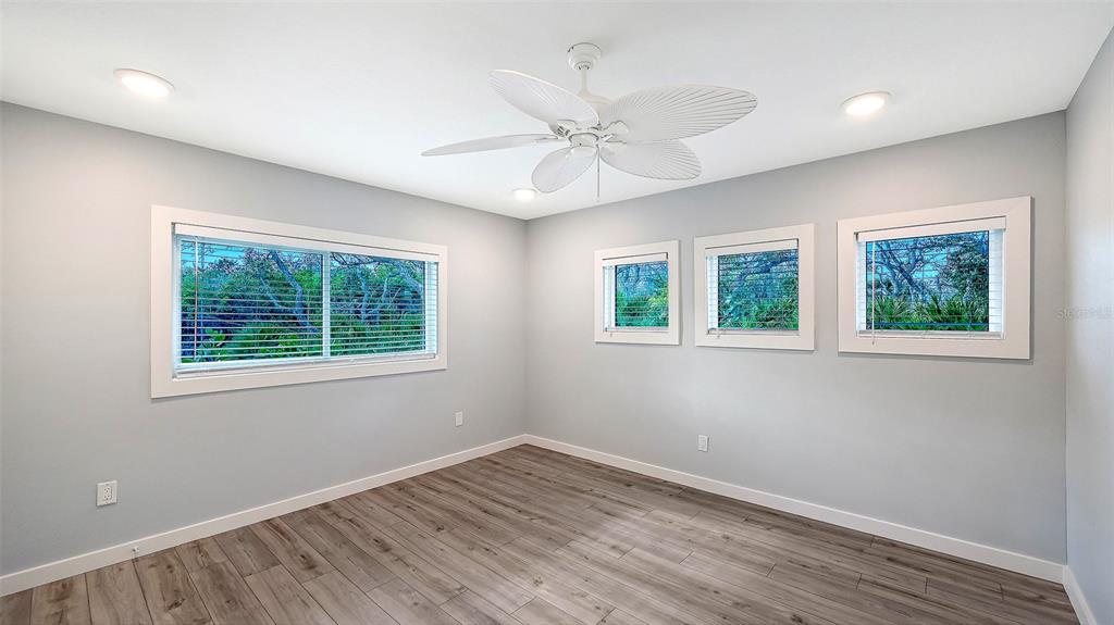 7221 Plovers Way Sarasota, FL 34242 - Photo 38 of 100 a view of an empty room with wooden floor and a window