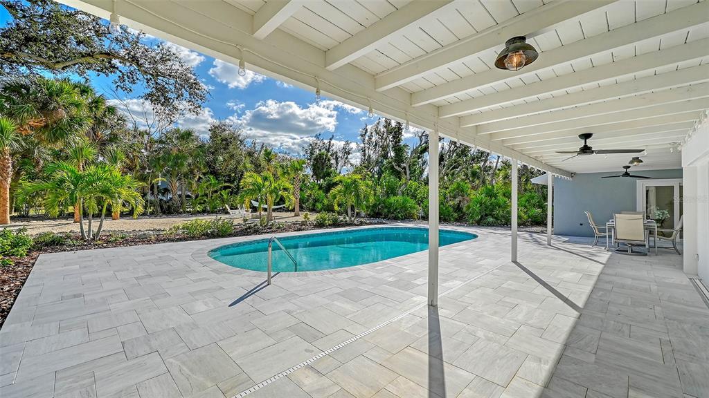 7221 Plovers Way Sarasota, FL 34242 - Photo 48 of 100 a view of a patio with a table and chairs under an umbrella
