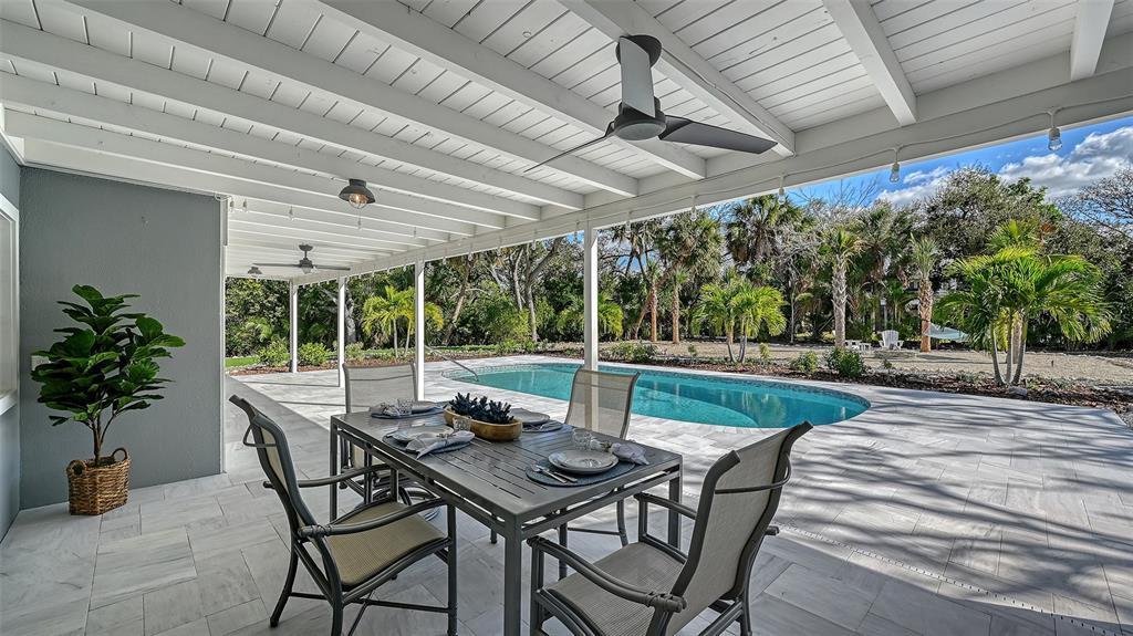 7221 Plovers Way Sarasota, FL 34242 - Photo 49 of 100 a view of a patio with a table and chairs and potted plants