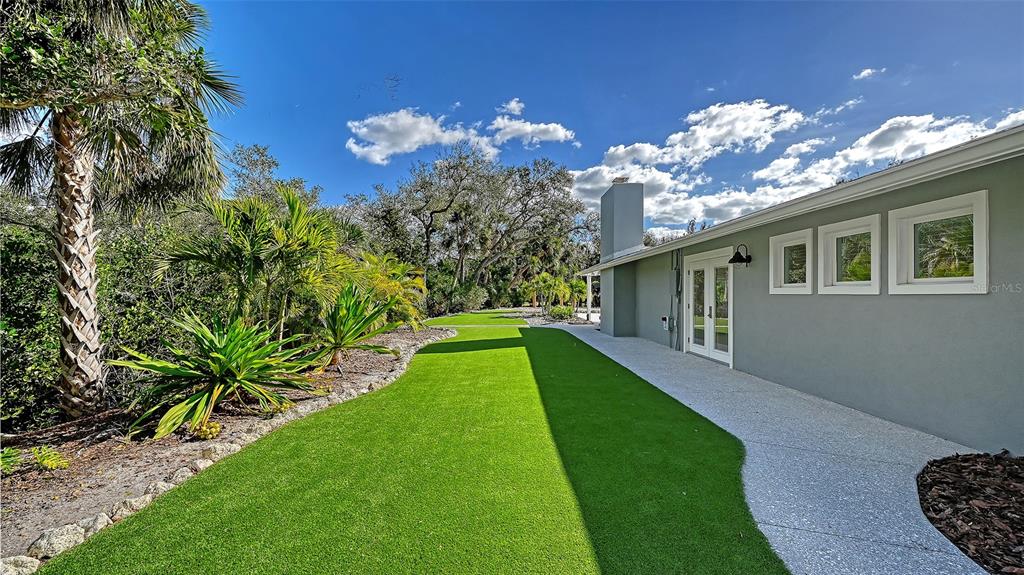 7221 Plovers Way Sarasota, FL 34242 - Photo 57 of 100 a view of a house with a big yard potted plants and a large tree