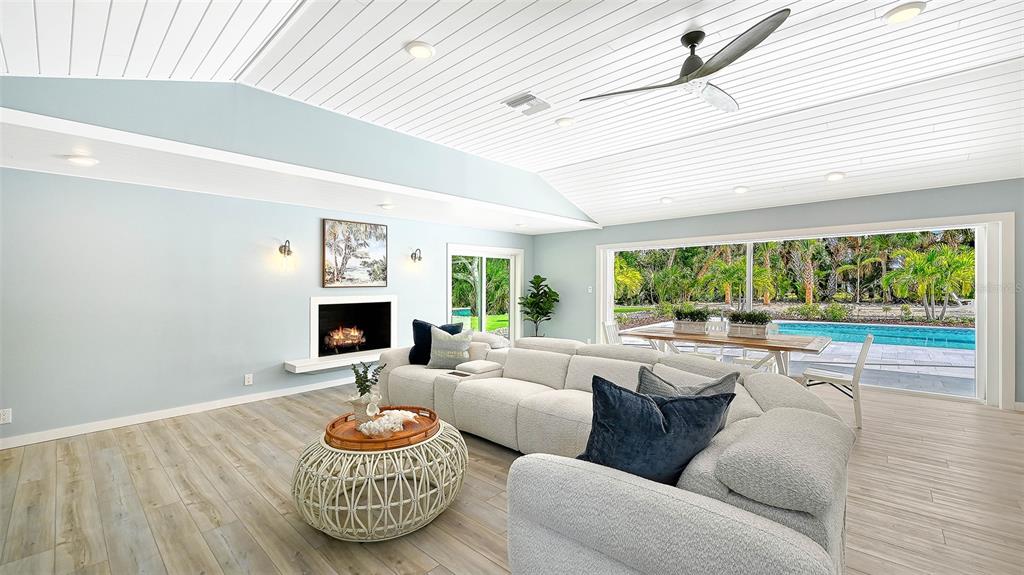 7221 Plovers Way Sarasota, FL 34242 - Photo 9 of 100 a living room with hard wood floor and a fireplace