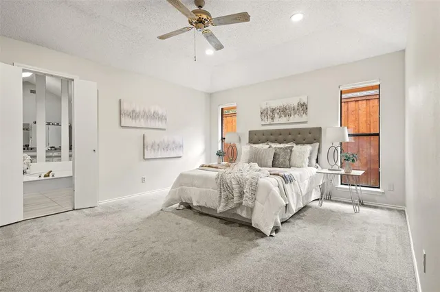a spacious bedroom with a bed and a chandelier
