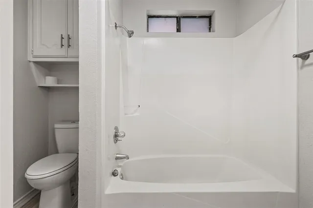 a white bath tub sitting next to a toilet
