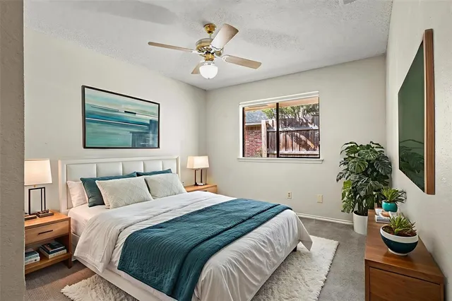 a bedroom with bed and a painting on the wall