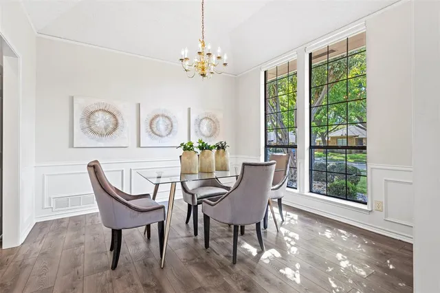 a view of a dining room with furniture a chandelier and wooden floor