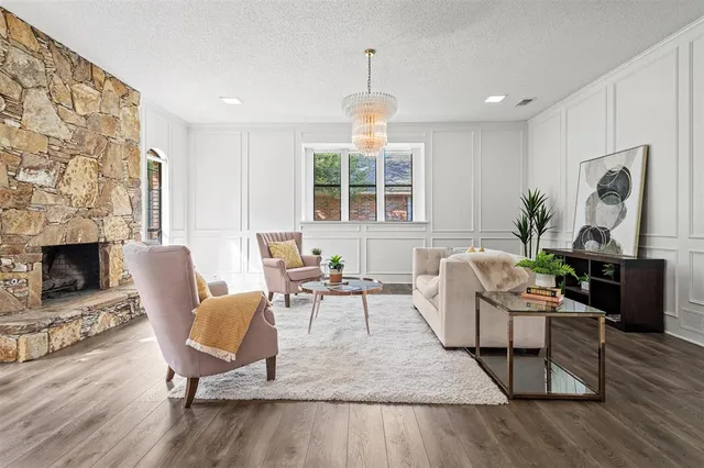 a living room with furniture a fireplace and a large window