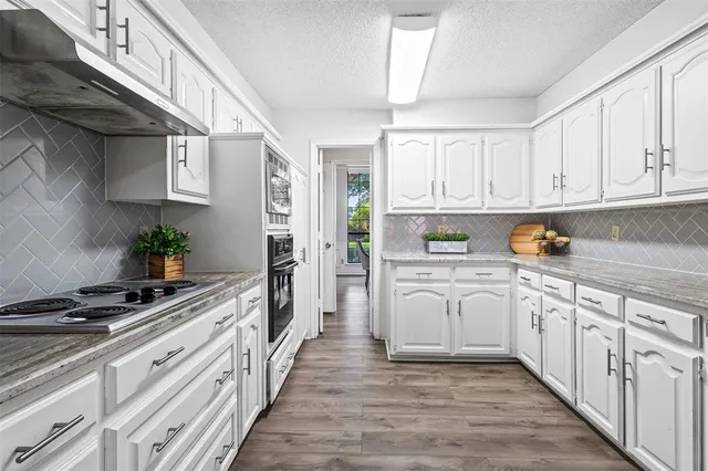 a kitchen with granite countertop a sink and cabinets