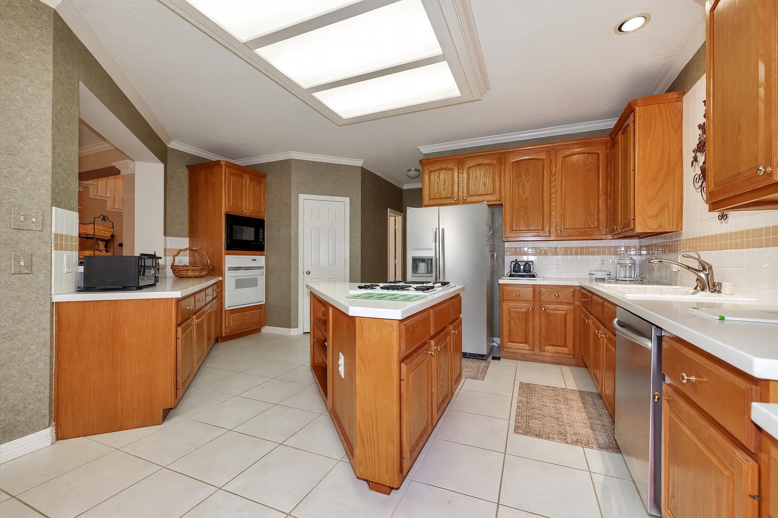 5718 Oakmoss Trail Spring, TX 77379 - Photo 15 of 48 a kitchen with stainless steel appliances granite countertop a stove top oven a sink dishwasher and a refrigerator with wooden cabinets