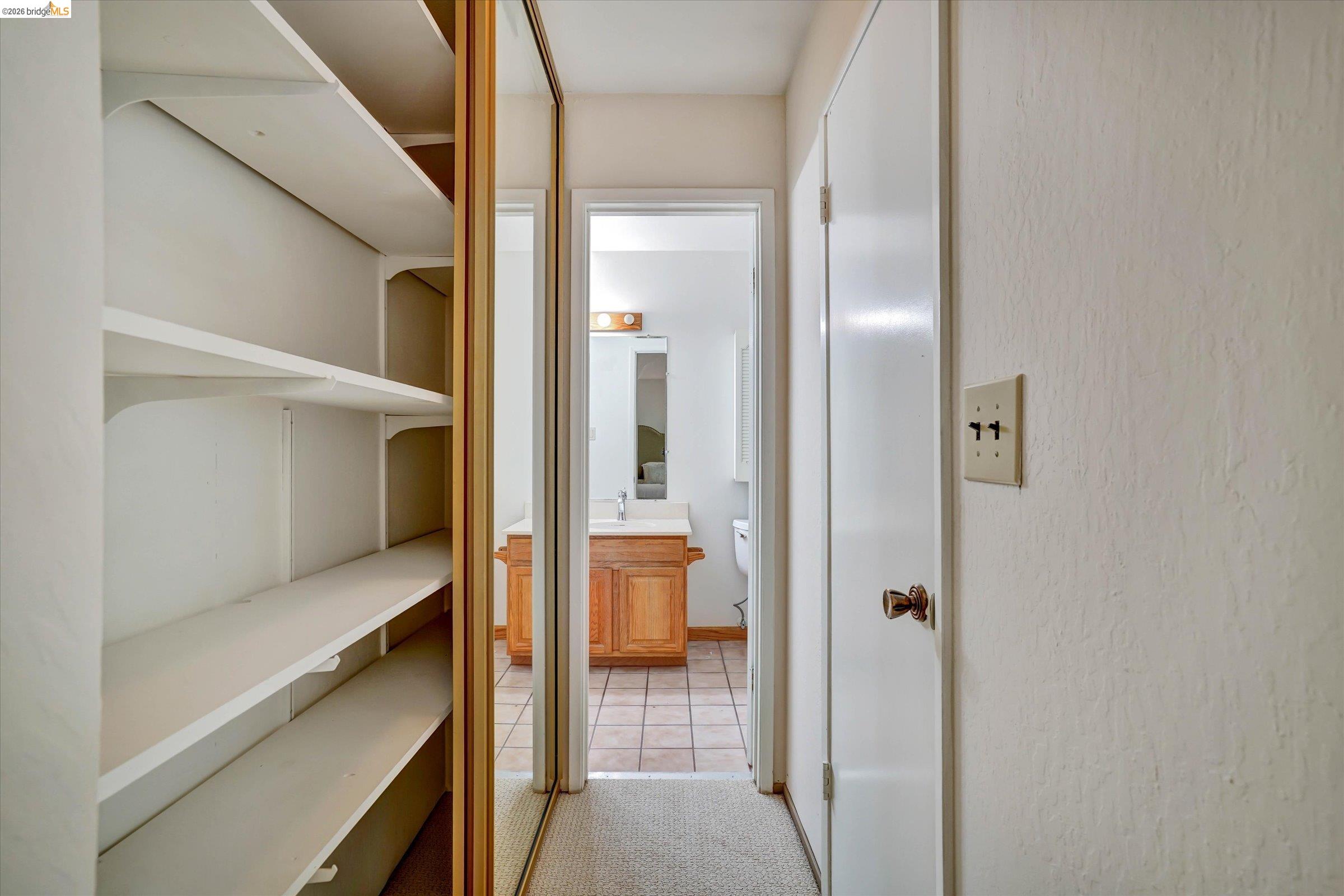 2826 Wright Avenue Pinole, CA 94564 - Photo 45 of 70 Built-in shelving unit with multiple white shelves, adjacent to a mirrored closet door