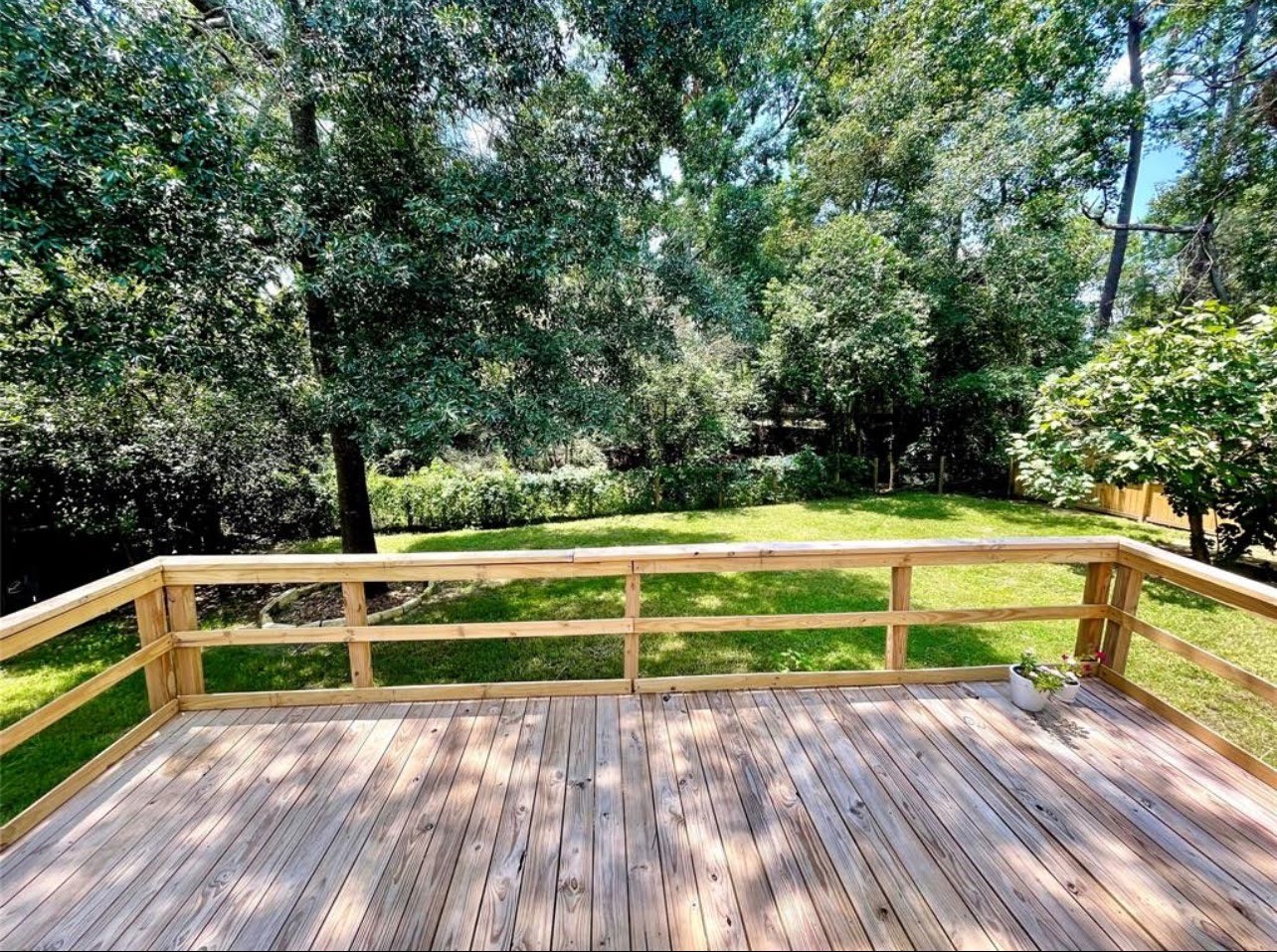 1811 Tickner Street Conroe, TX 77301 - Photo 17 of 20 a view of backyard with deck and trees