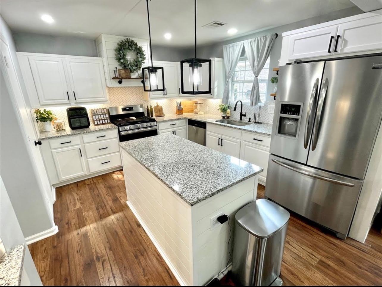 1811 Tickner Street Conroe, TX 77301 - Photo 6 of 20 a kitchen with white cabinets and stainless steel appliances