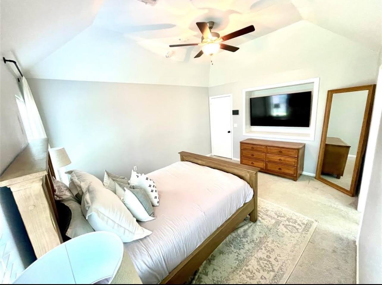 1811 Tickner Street Conroe, TX 77301 - Photo 9 of 20 a bedroom with a bed and a flat screen tv
