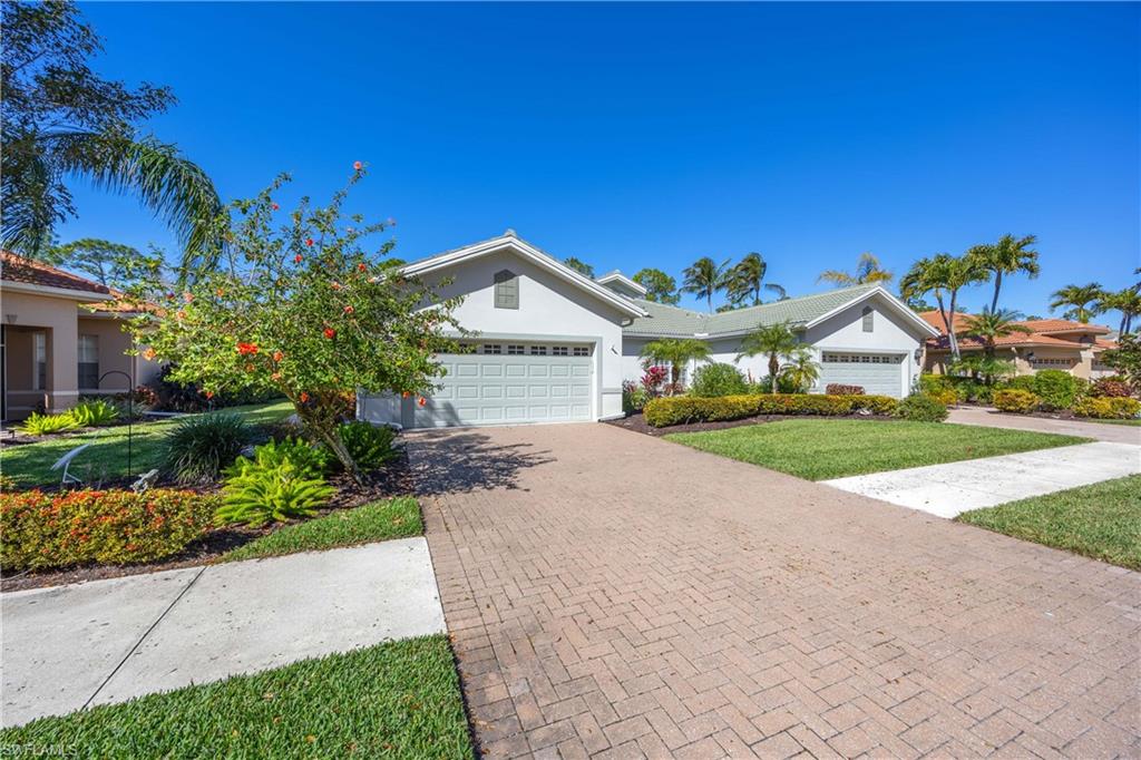 3589 Periwinkle Way Naples, FL 34114 - Photo 23 of 39 a front view of a house with a yard and garage