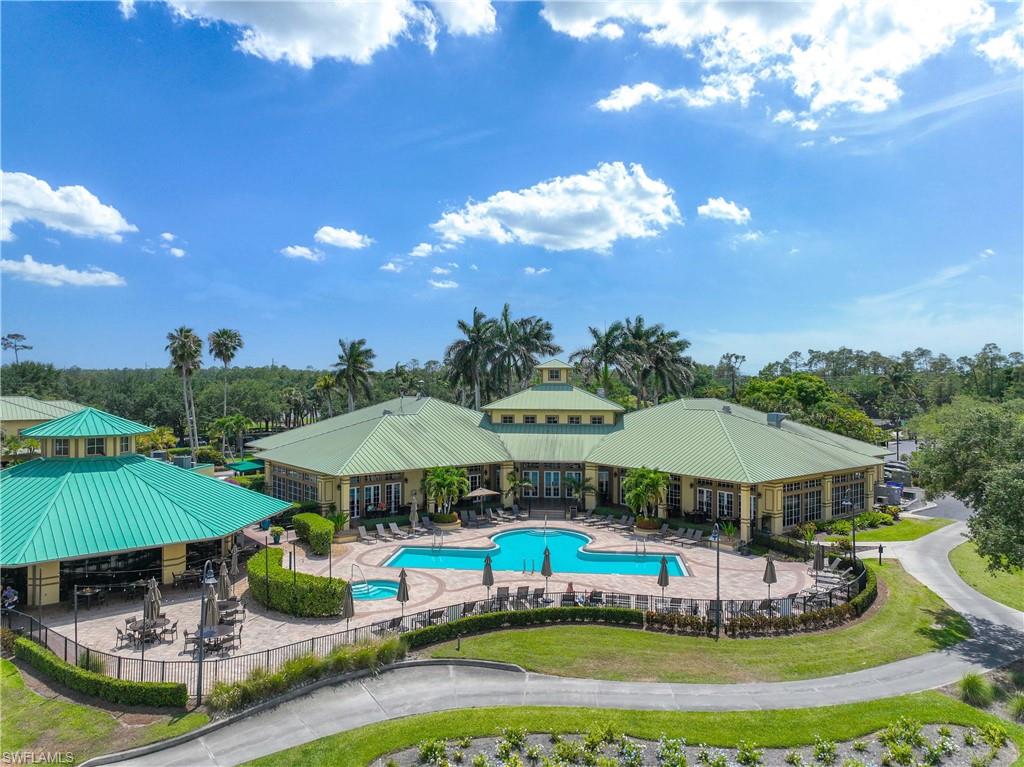 3589 Periwinkle Way Naples, FL 34114 - Photo 29 of 39 a view of a swimming pool with lawn chairs under an umbrella