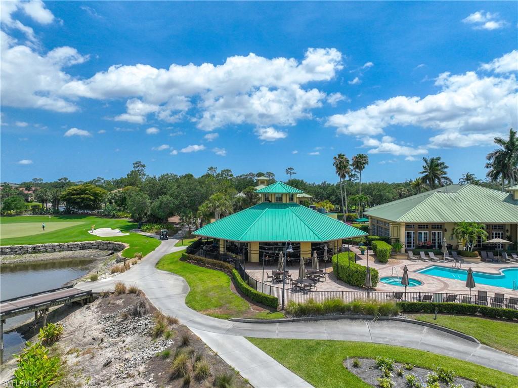 3589 Periwinkle Way Naples, FL 34114 - Photo 30 of 39 a view of a swimming pool with lawn chairs under an umbrella