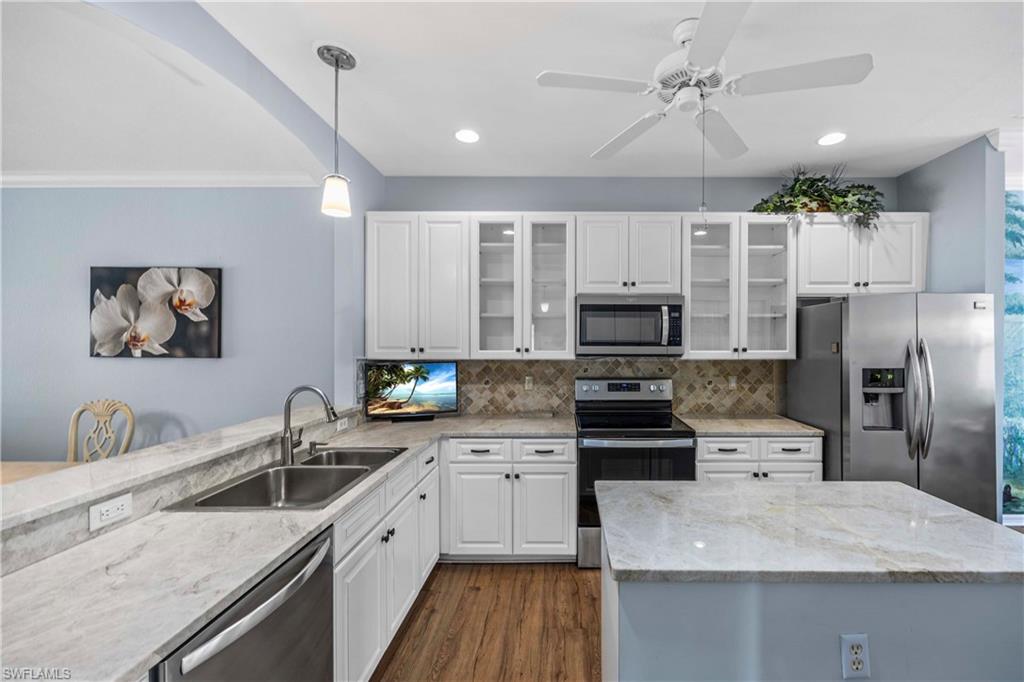 3589 Periwinkle Way Naples, FL 34114 - Photo 9 of 39 a kitchen with a sink appliances and cabinets