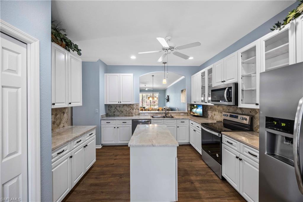 3589 Periwinkle Way Naples, FL 34114 - Photo 10 of 39 a large kitchen with cabinets stainless steel appliances and a counter top space